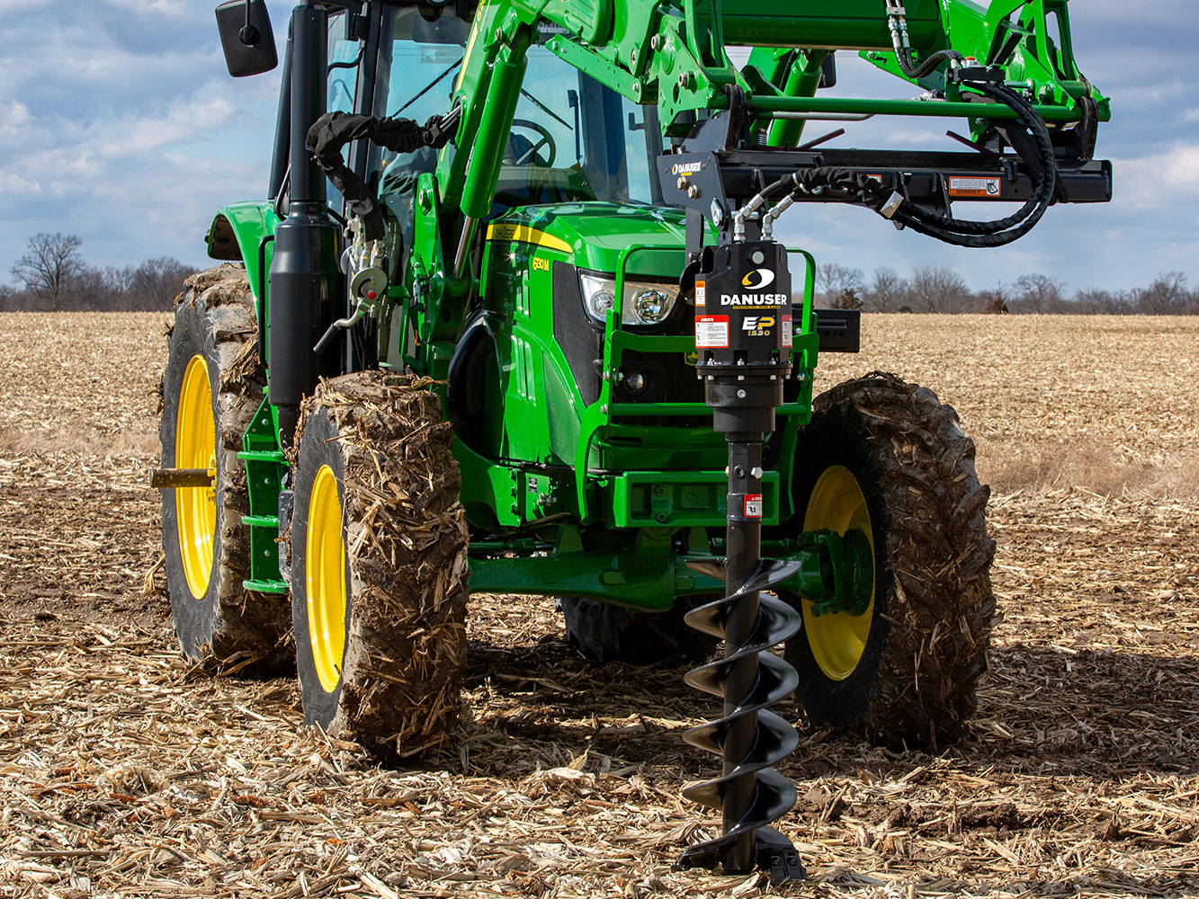 Image showing Danuser EP 1530 Auger Drive on John Deere tractor, drilling into ground in a farm field