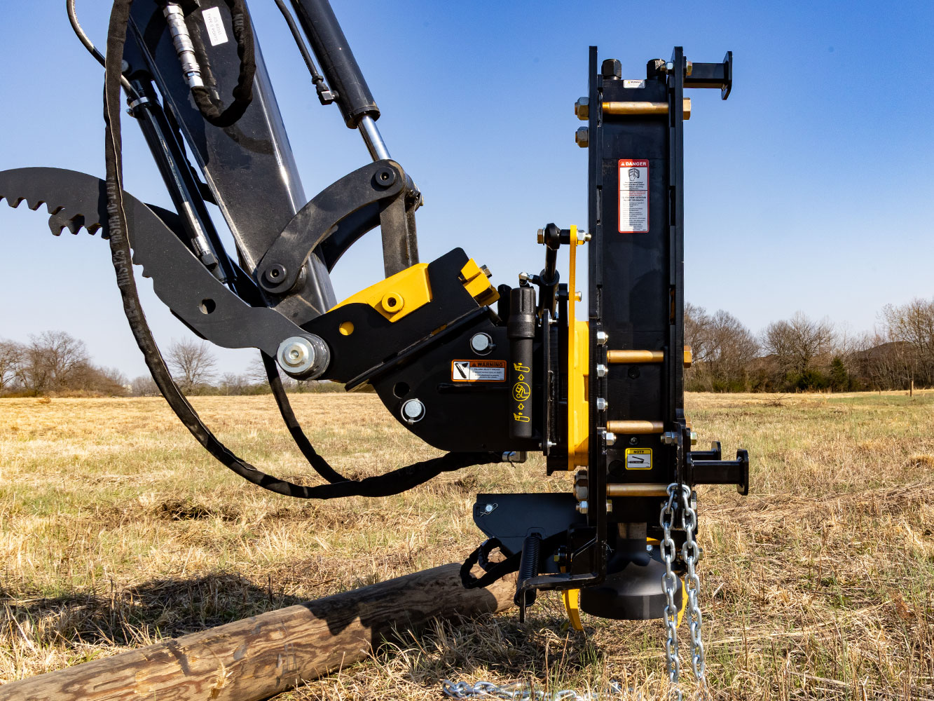 Image showing side view of Danuser Hornet T8-RR post driver on Mini John Deere 50P Excavator after using chain to remove wood post