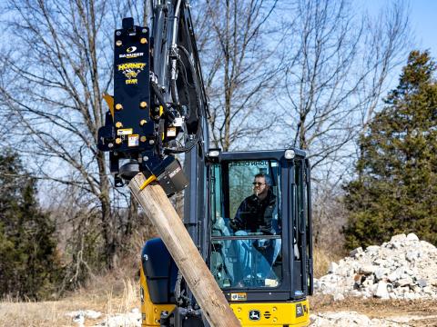 Image showing Danuser Hornet T8-RR post driver on Mini John Deere 50P Excavator using grapple to hold tilted wood post