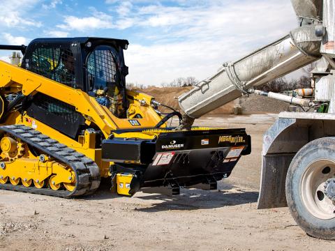Image showing Danuser Mega Mixer on CAT 289D Skid Steer being filled with cement from truck at job site, shown in action