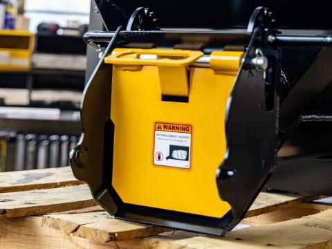Image showing Close-up of gate on Danuser Mega Mixer Bucket showing yellow and black mechanism with visible warning label