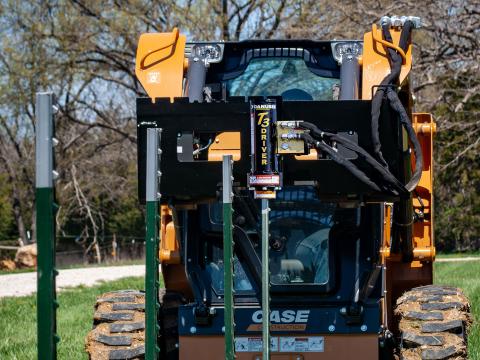 Image shows Danuser T3 post driver on Case SR220 Skid Steer driving a line of t-posts into the ground in a field