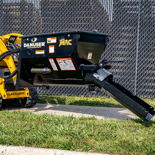 Mini MAC material handling bucket with its chute connected and attached to a mini skid steer